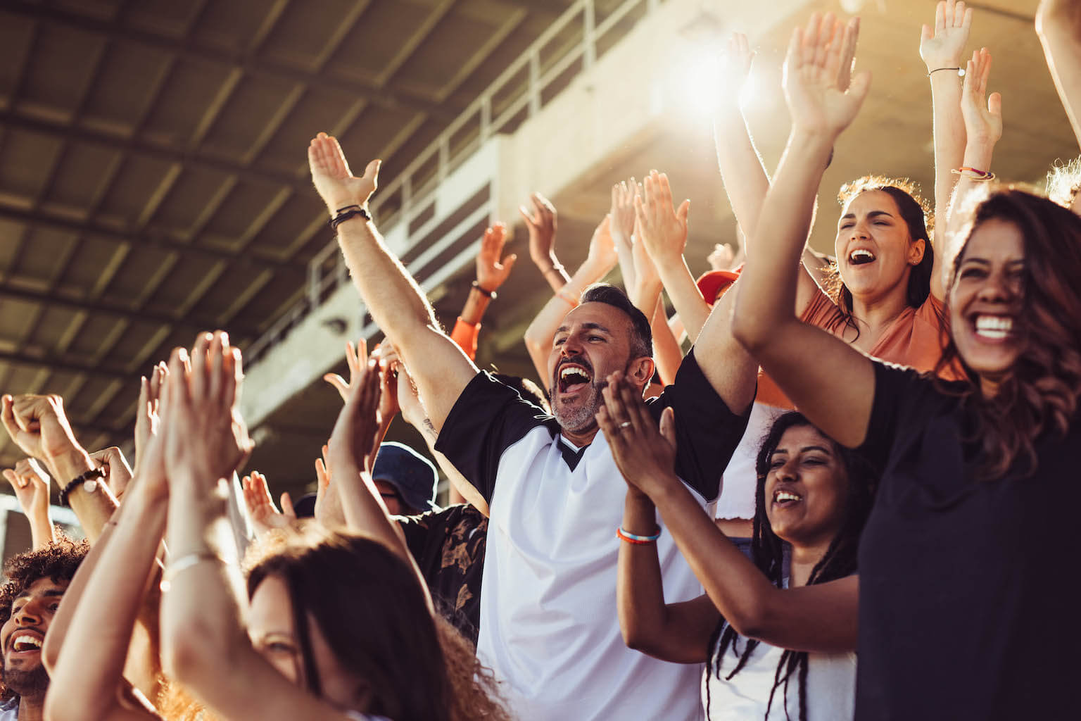 Parents enthusiastically cheering for their children during a soccer match in a stadium